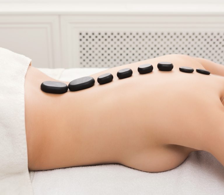 Heated stones arranged along the back during a hot stone massage